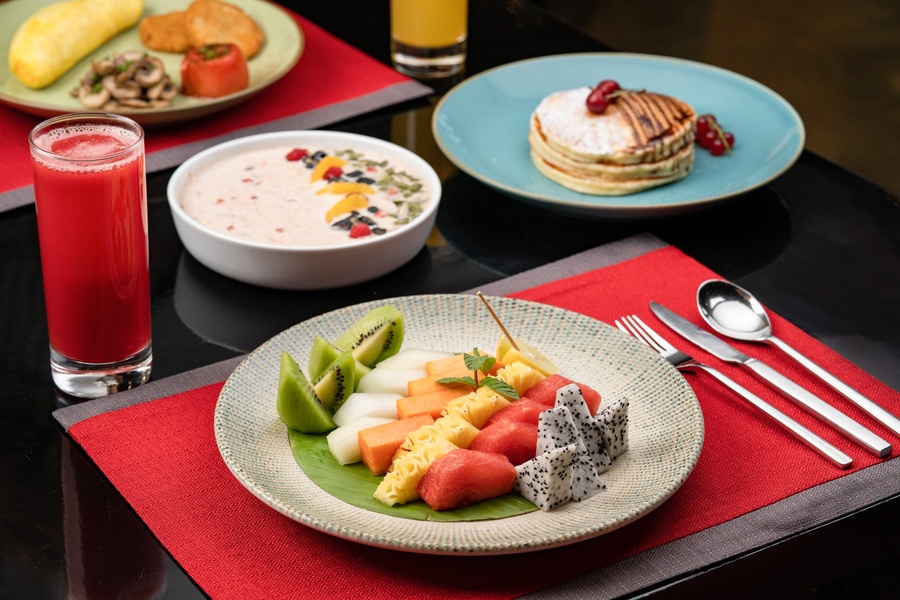 Breakfast spread with fresh fruit, pancakes, cereal and juice at Food Exchange Aerocity Delhi