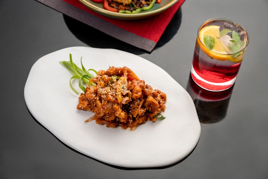 Asian-style crispy dish with sesame seeds and a refreshing drink at Food Exchange Aerocity Delhi